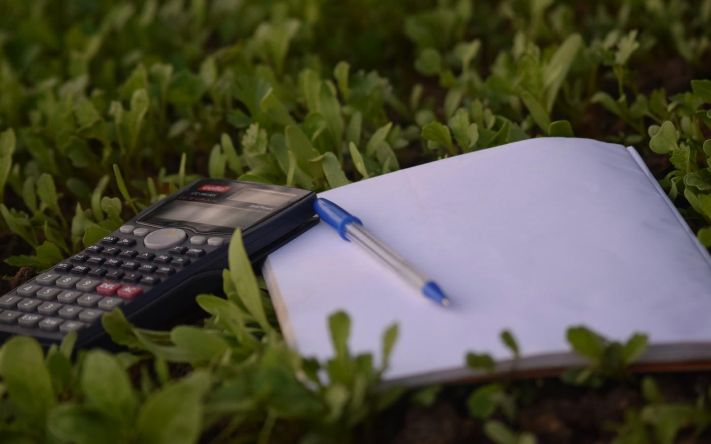 blue ballpoint pen on paper beside calculator by Ashraf Ali courtesy of Unsplash.