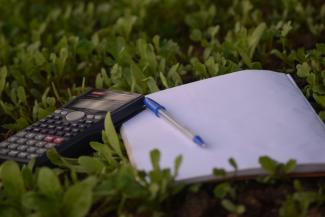 blue ballpoint pen on paper beside calculator by Ashraf Ali courtesy of Unsplash.